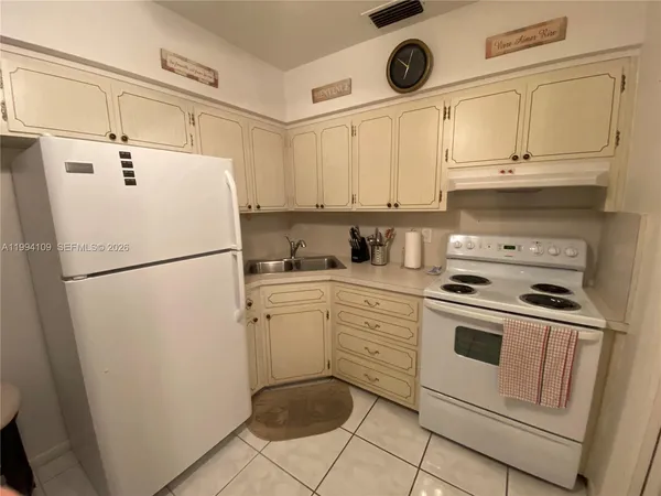a kitchen with a refrigerator sink stove and cabinets