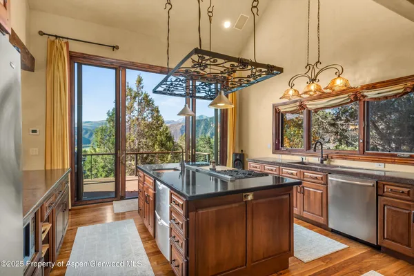 a kitchen with stainless steel appliances granite countertop a sink and a stove