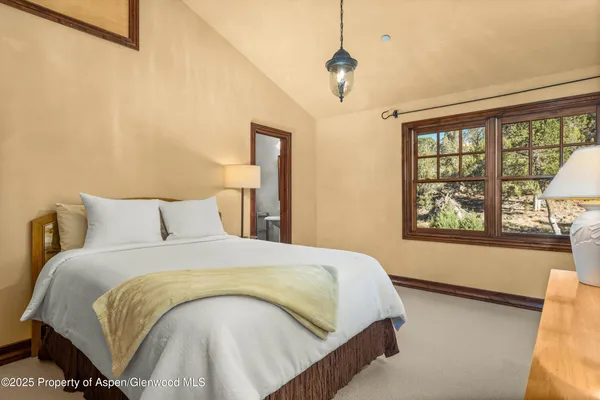 a bedroom with a large bed and a large window