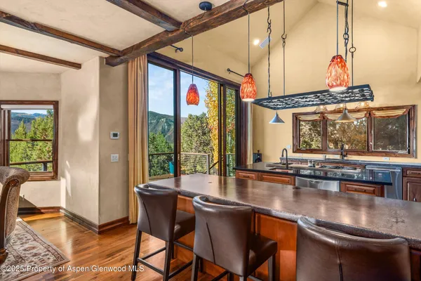 a dining room with wooden floor and large windows