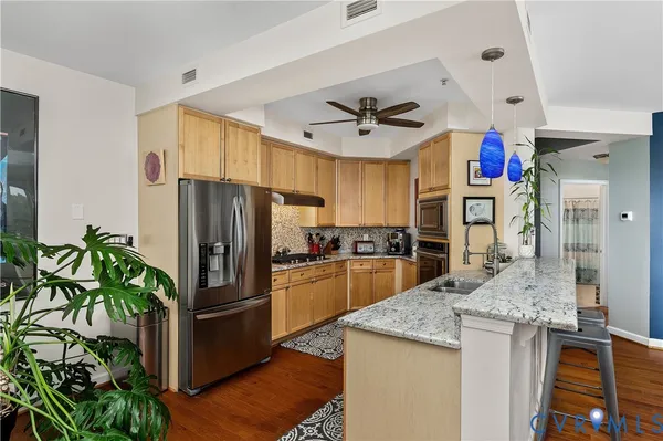 a kitchen with granite countertop a refrigerator and a sink