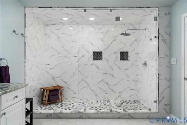 a bathroom with a granite countertop sink a mirror a vanity and bathtub