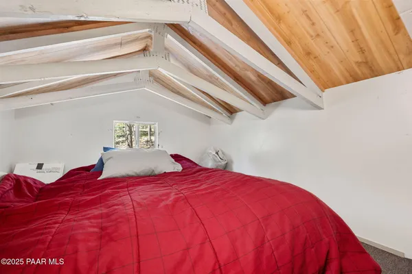 a large bed sitting in a bedroom next to a window