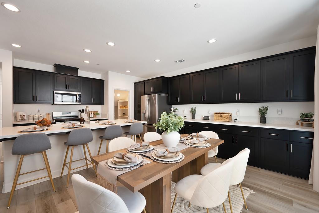 17500 Beachwood Road Lathrop, CA 95330 - Photo 29 of 78 a kitchen with stainless steel appliances kitchen island granite countertop a dining table chairs stove top oven and sink