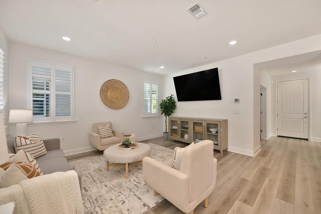 17500 Beachwood Road Lathrop, CA 95330 - Photo 32 of 78 a living room with furniture a fireplace and a flat screen tv
