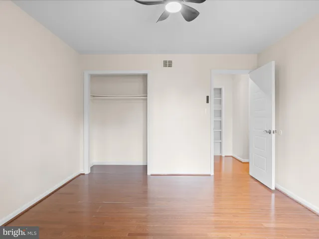 an empty room with windows and fan