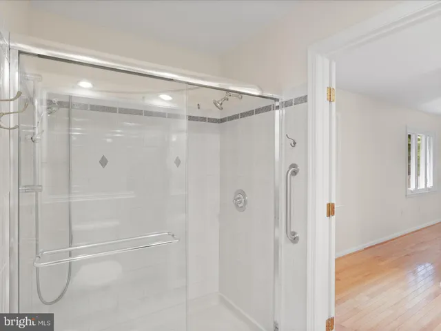a bathroom with a bathtub shower sink vanity mirror and toilet