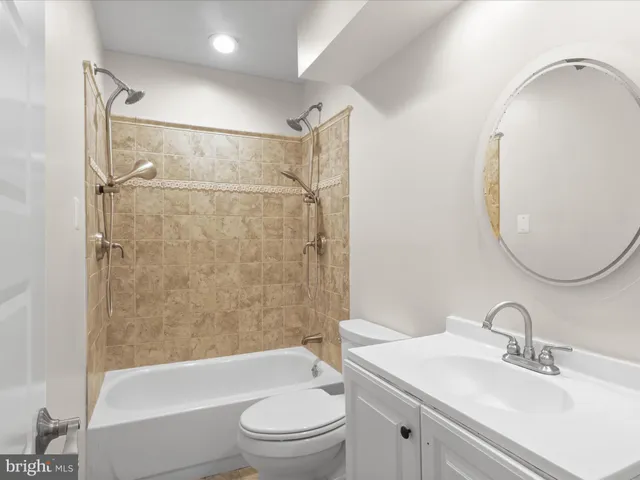 a view of an empty room with wooden floor and a fireplace