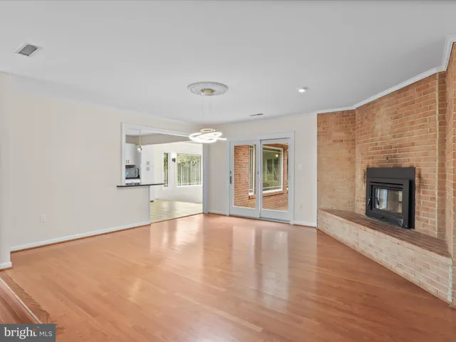 a view of an empty room with a fireplace and a window