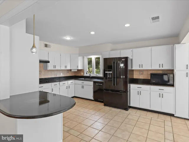 a kitchen with granite countertop a sink stainless steel appliances and cabinets