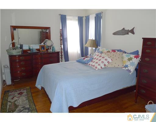 1707 River Road Belmar, NJ 07719 - Photo 8 of 17 a bedroom with a bed and a mirror on dresser