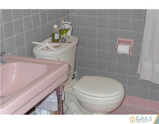 1707 River Road Belmar, NJ 07719 - Photo 10 of 17 a bathroom with a sink a toilet and a mirror