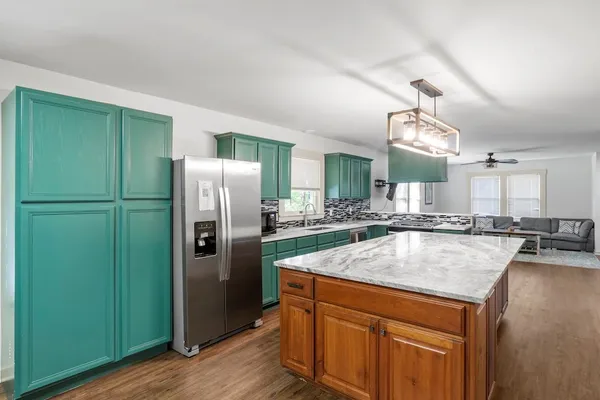 a kitchen with stainless steel appliances granite countertop a refrigerator a sink dishwasher a stove and a refrigerator
