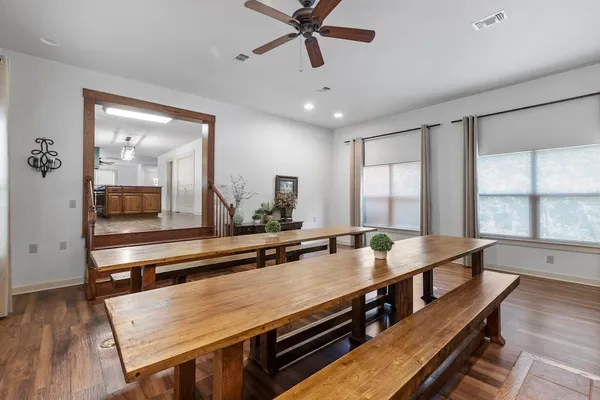 a kitchen with a table chairs and wooden floor