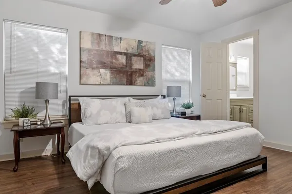 a bedroom with a bed a mirror with a large window