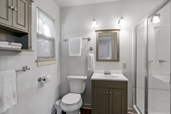 a bathroom with a sink a toilet and shower