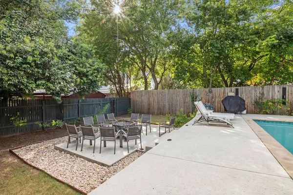 a view of a patio with table and chairs with wooden fence and plants