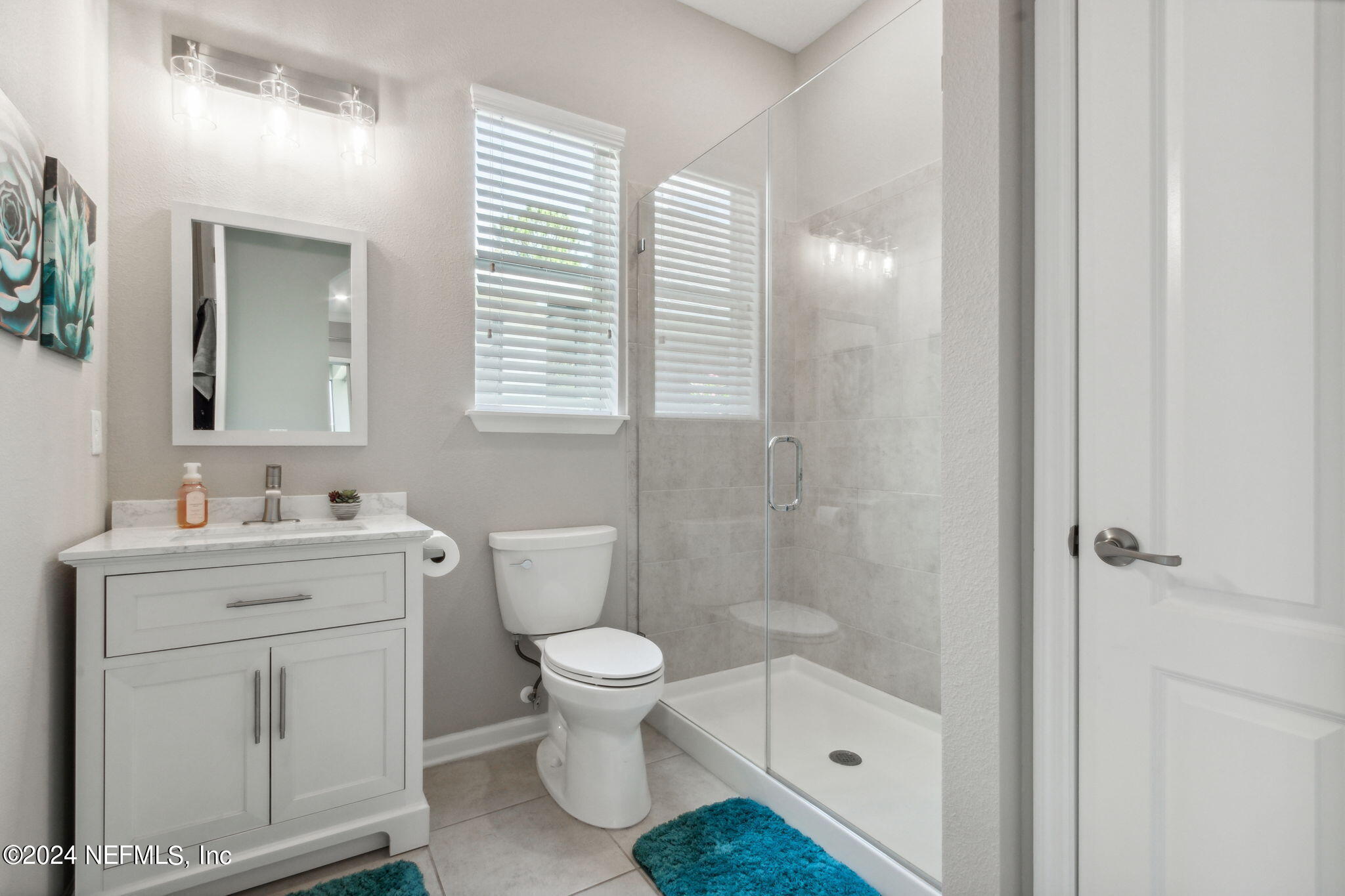 369 Medio Drive St. Augustine, FL 32095 - Photo 18 of 25 a bathroom with a granite countertop toilet a sink a mirror a shower and vanity