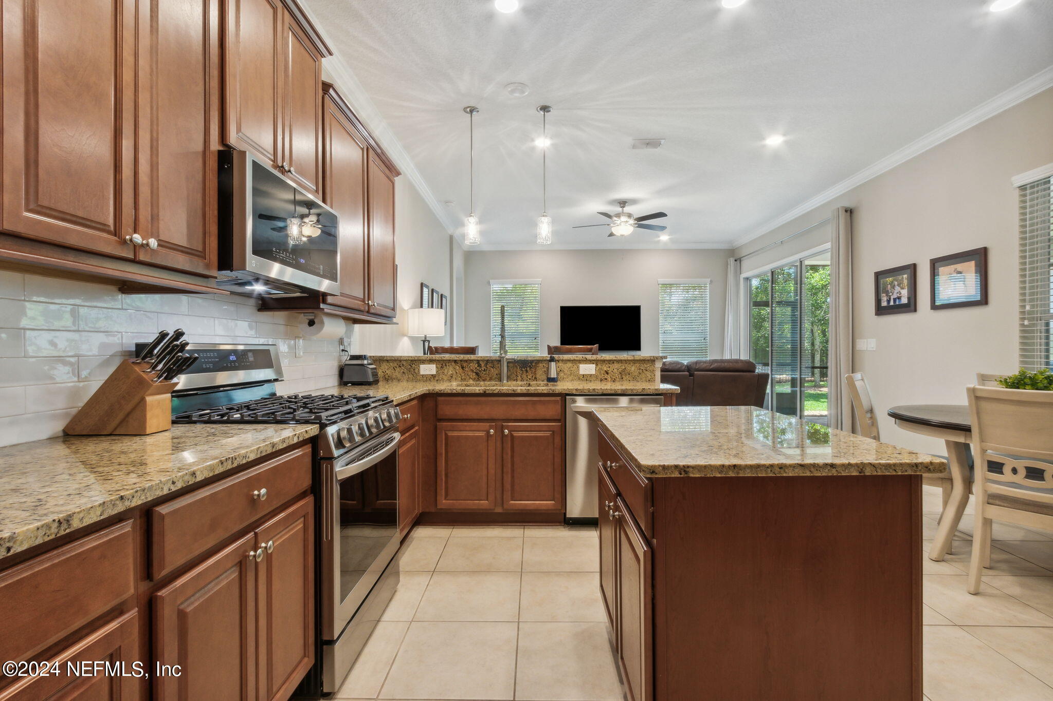369 Medio Drive St. Augustine, FL 32095 - Photo 7 of 25 a kitchen with kitchen island granite countertop a sink counter top space appliances and cabinets