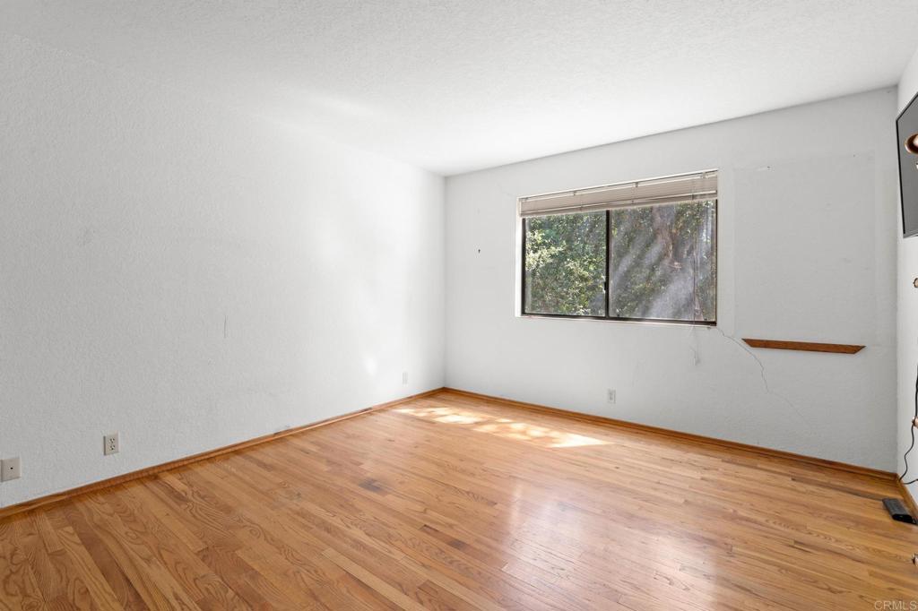 5041 Pine Ridge Avenue Julian, CA 92036 - Photo 16 of 27 an empty room with wooden floor and windows