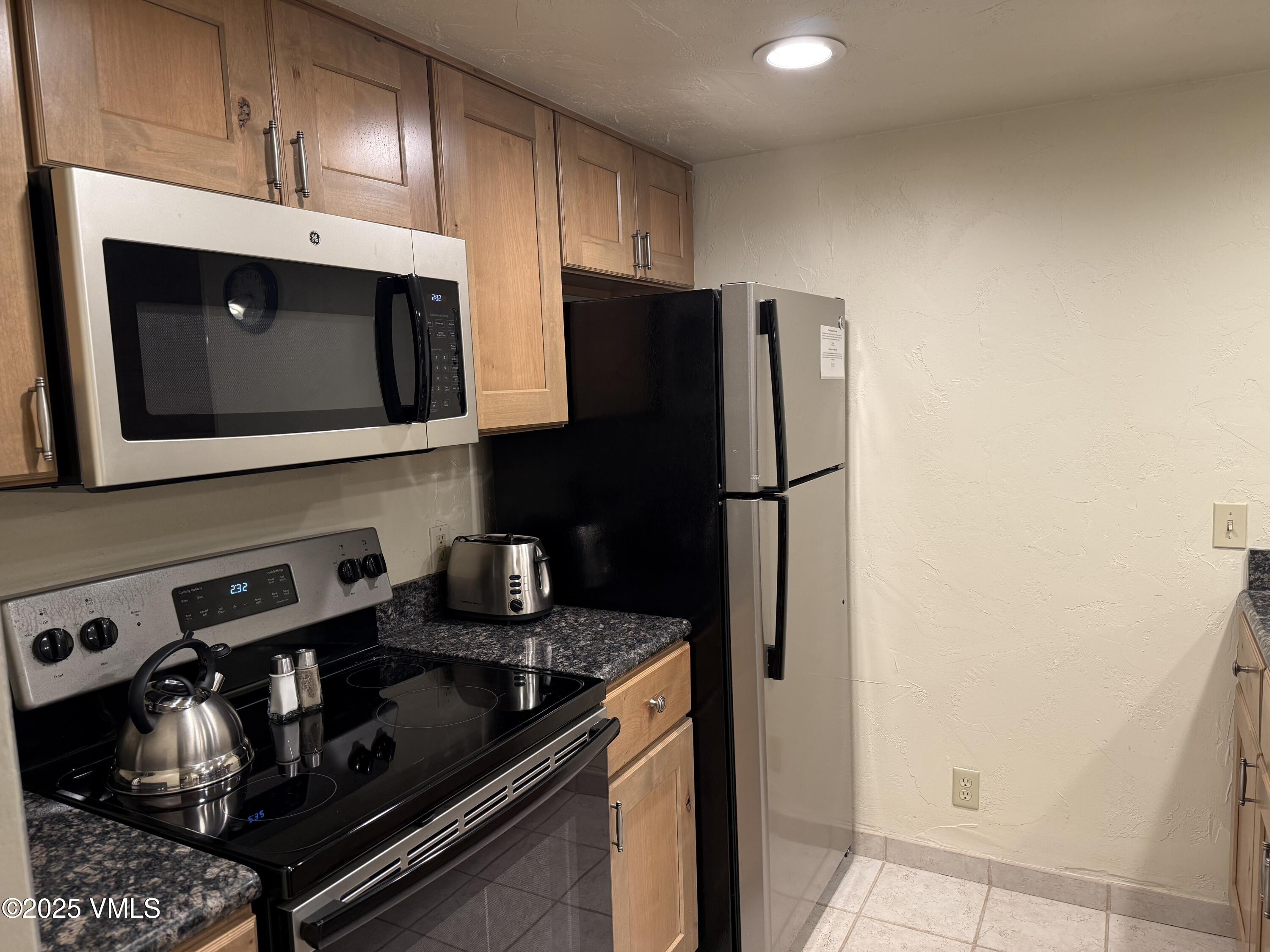 1020 Vail View Drive, Unit 321215 Vail, CO 81657 - Photo 1 of 23 a kitchen with stainless steel appliances granite countertop a refrigerator and a stove top oven