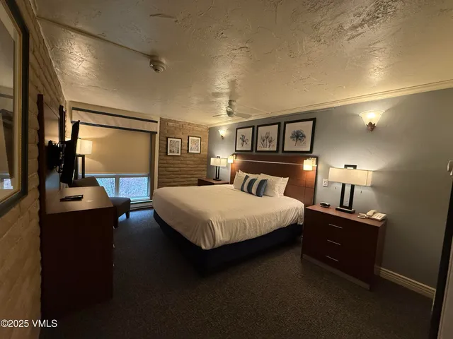 a bedroom with a bed and a lamp on table