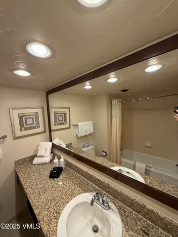 a bathroom with a granite countertop sink and a mirror