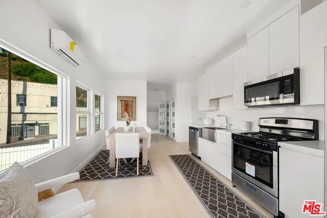 a kitchen with stainless steel appliances a stove a sink a microwave a refrigerator and cabinets