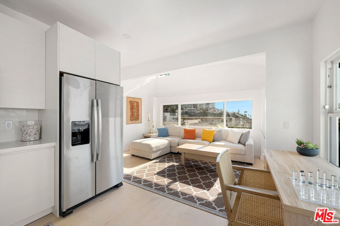 117 West Channel Road, Unit 119 Santa Monica, CA 90402 - Photo 3 of 10 a living room with furniture large windows and wooden floor