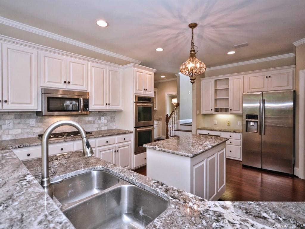 13504 Scanlan Way Davidson, NC 28036 - Photo 9 of 23 a kitchen with stainless steel appliances granite countertop a sink refrigerator stove and microwave
