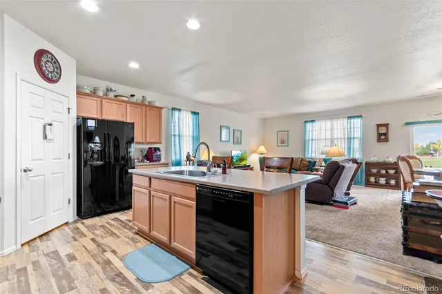 a kitchen with a table chairs a sink dishwasher and cabinets with wooden floor