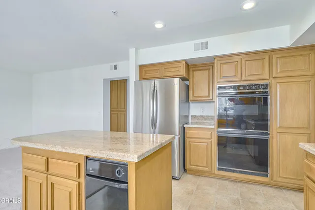 a kitchen with stainless steel appliances granite countertop a stove a sink and a refrigerator