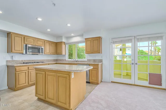 a kitchen with granite countertop sink stove and cabinets