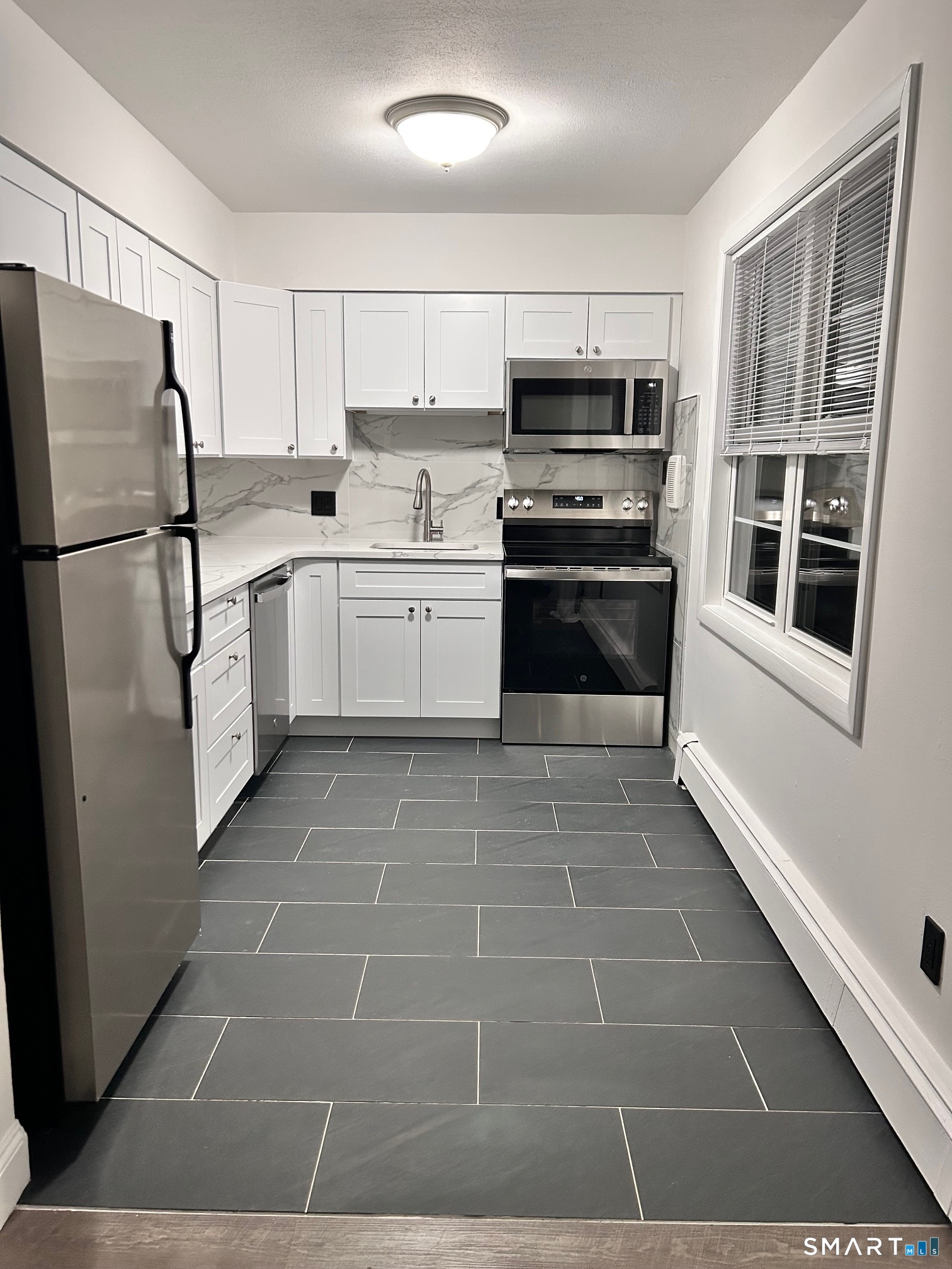 1109 Waterbury Road, Unit 1A Cheshire, CT 06410 - Photo 5 of 15 a kitchen with a stove a microwave and a refrigerator