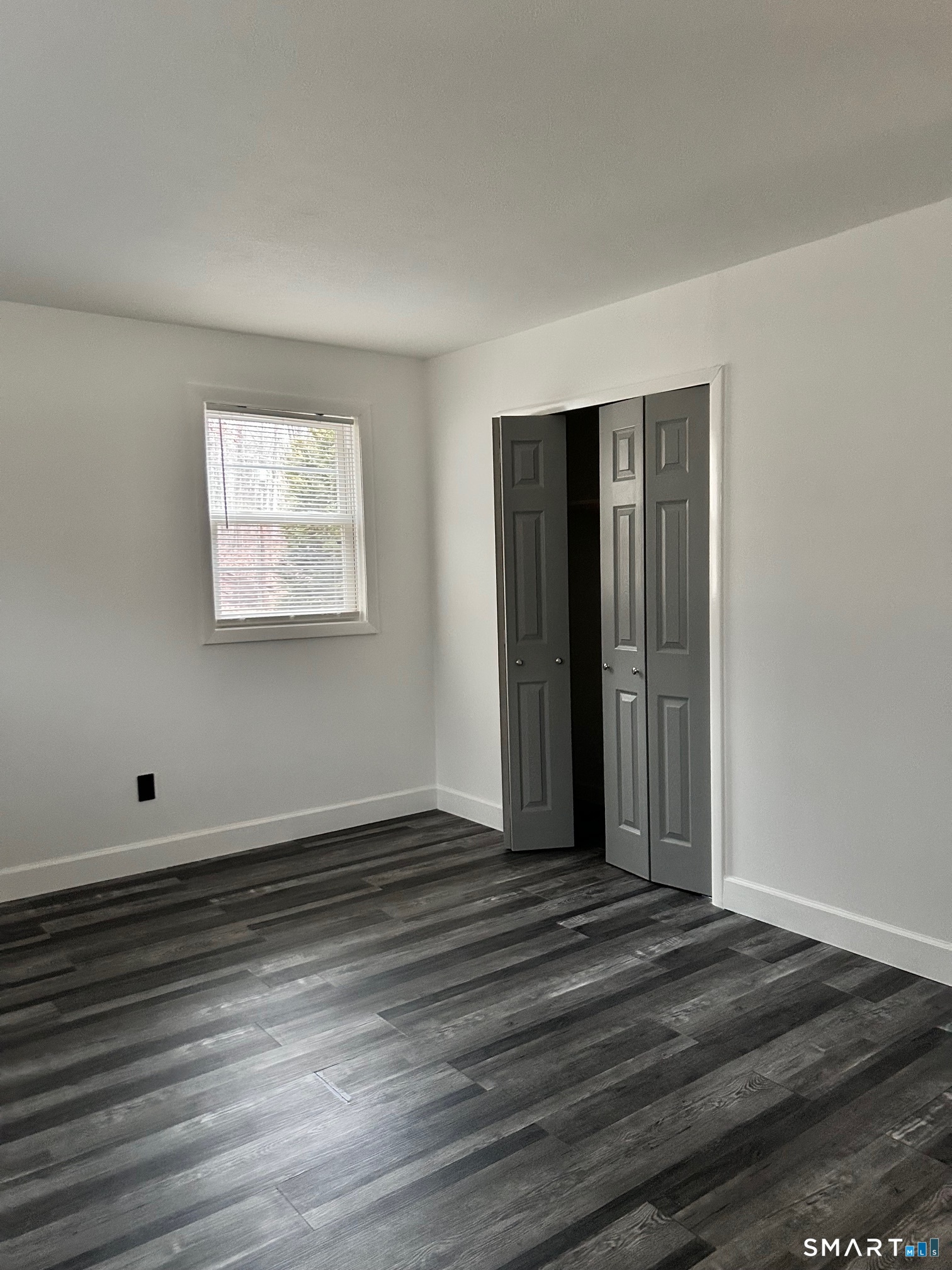 1109 Waterbury Road, Unit 1A Cheshire, CT 06410 - Photo 8 of 15 a view of an empty room with wooden floor and a window
