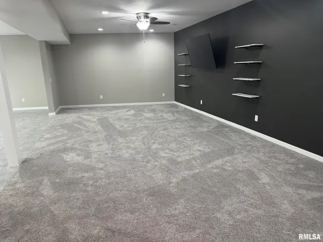 en empty room with windows and ceiling fan