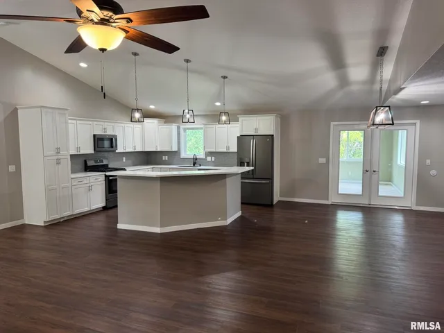 a view of a kitchen with a sink stainless steel appliances and cabinets