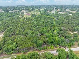 an aerial view of residential house with outdoor space and trees all around