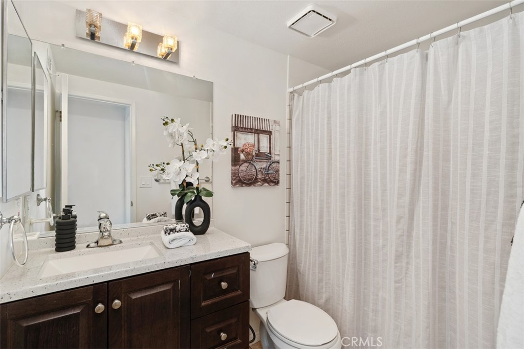 945 Redbud Street Brea, CA 92821 - Photo 24 of 31 a bathroom with a sink a toilet and shower curtain