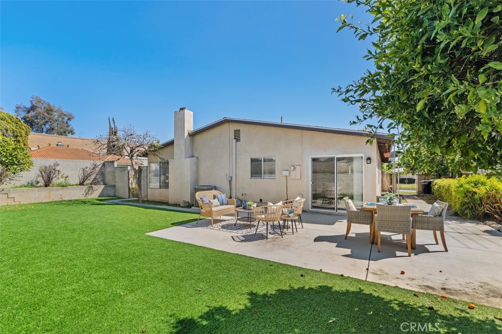 945 Redbud Street Brea, CA 92821 - Photo 28 of 31 a view of a patio with table and chairs potted plants and a large tree