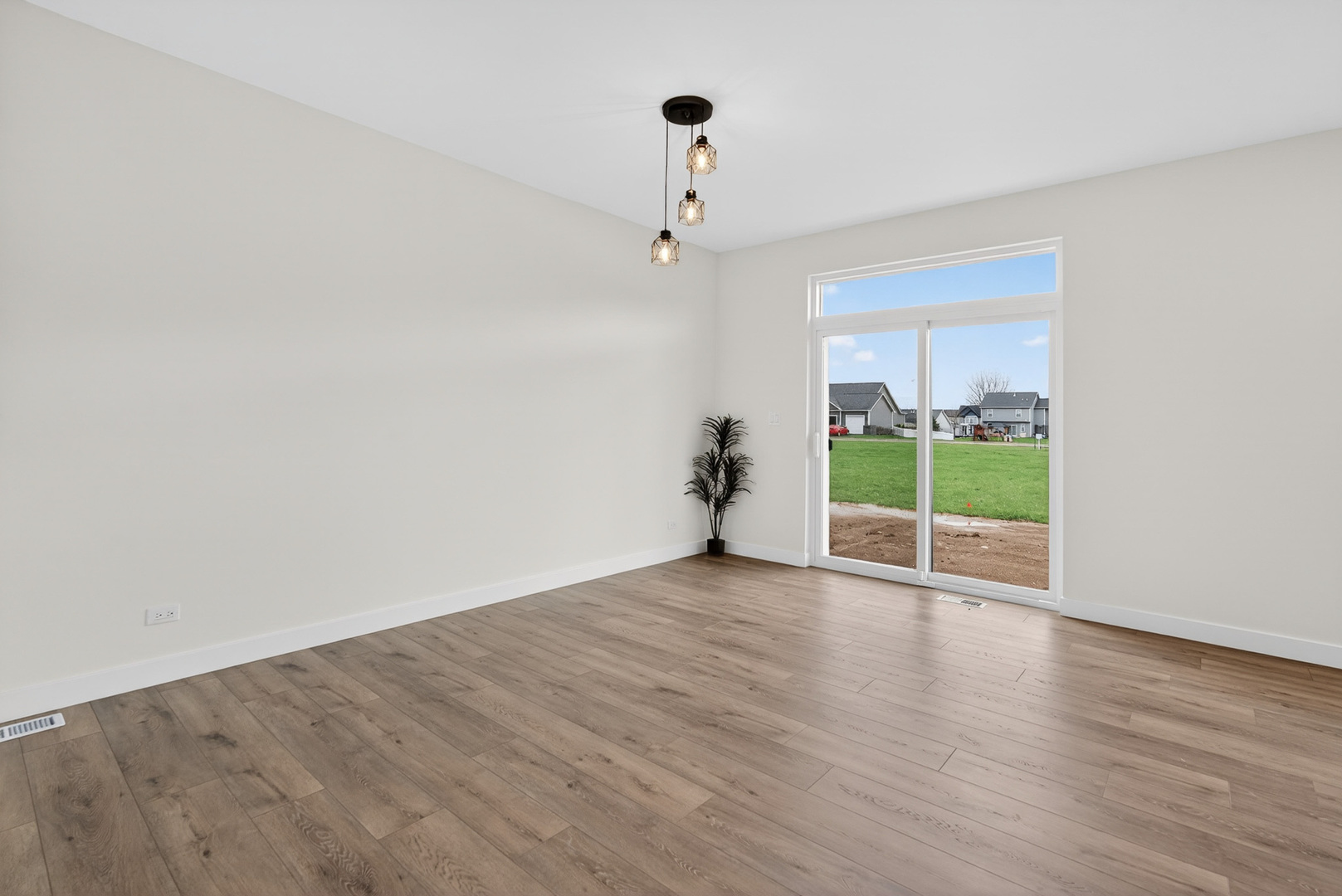 1002 Joshua Lane Genoa, IL 60135 - Photo 13 of 42 a view of an empty room with wooden floor and a window