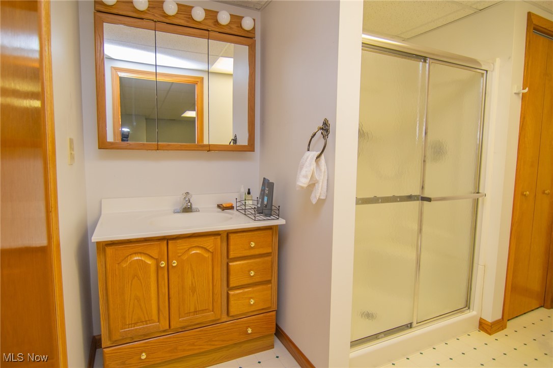 53350 High Ridge Road Bridgeport, OH 43912 - Photo 23 of 37 Full bathroom with tile patterned floors, vanity, baseboards, and a shower stall