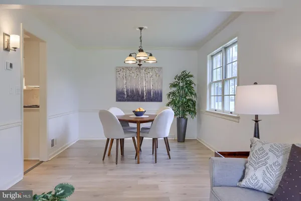 a dining room with furniture a chandelier and wooden floor