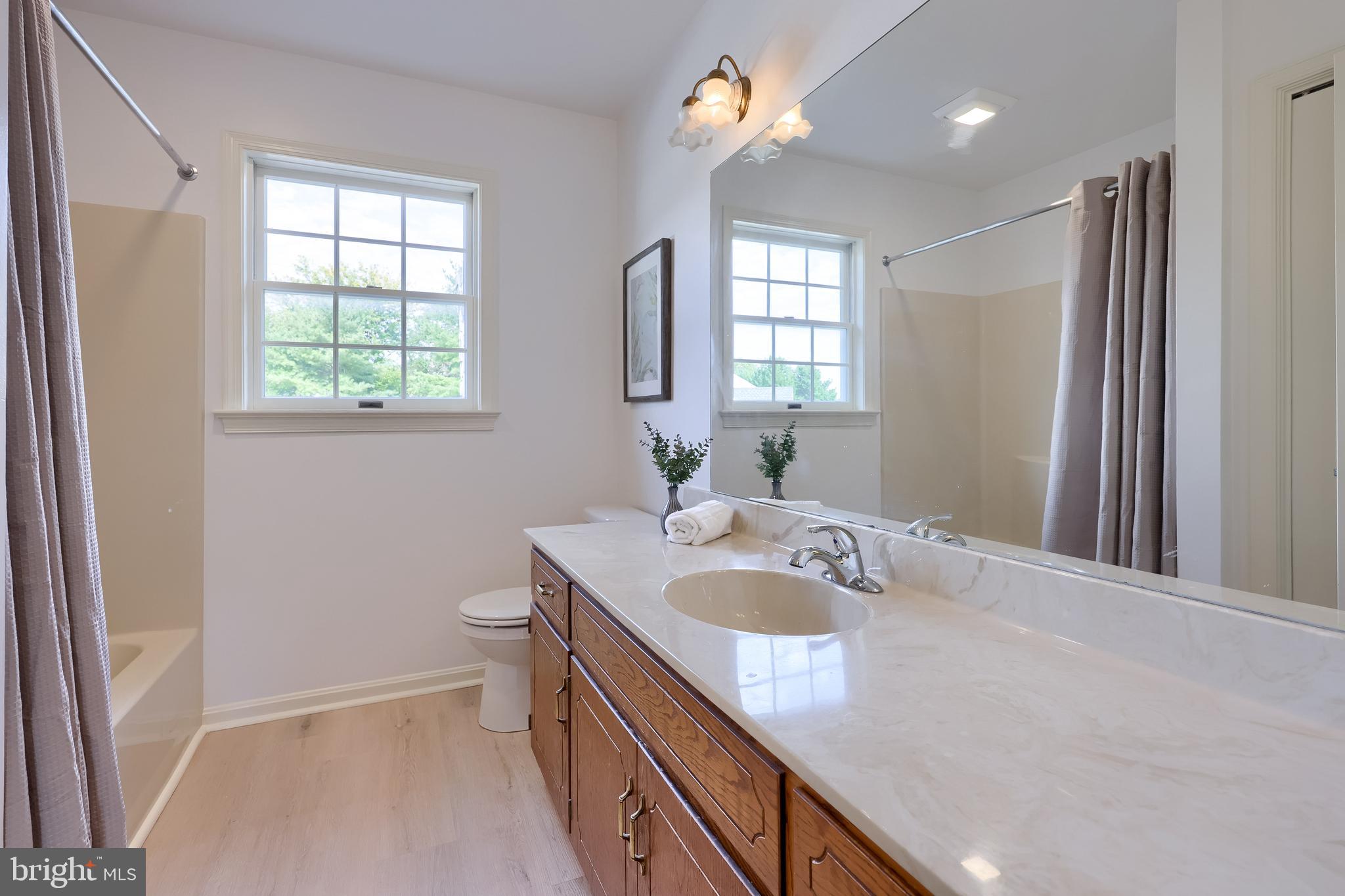 1 Brookwood Drive Lititz, PA 17543 - Photo 36 of 42 a bathroom with a granite countertop sink a toilet a large mirror and a window