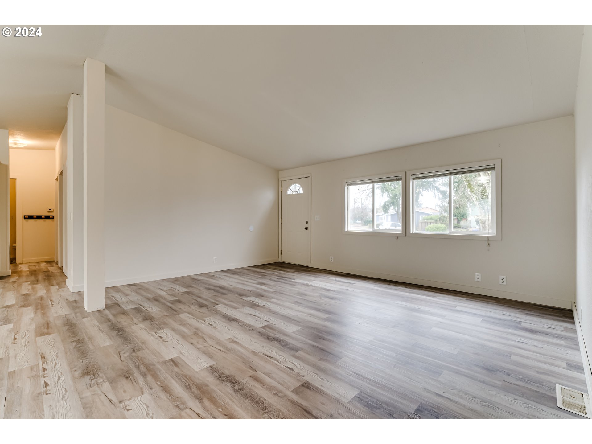 301 Smith Loop Springfield, OR 97478 - Photo 5 of 32 a view of an empty room with wooden floor and a window