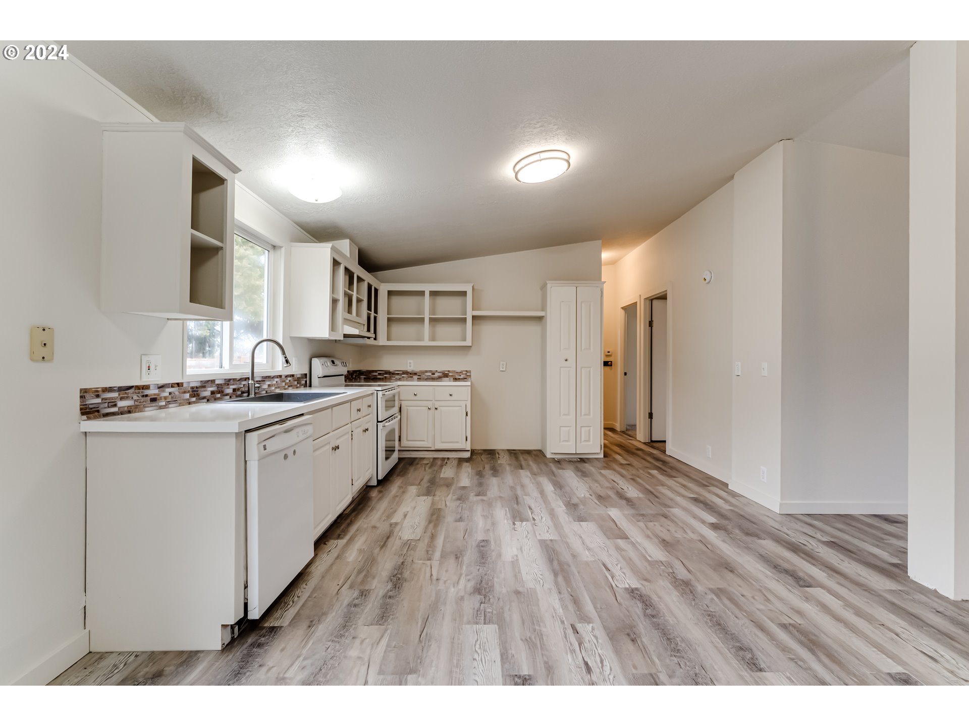 301 Smith Loop Springfield, OR 97478 - Photo 7 of 32 a kitchen with granite countertop a sink and a refrigerator