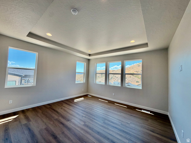 5885 Canyon Rim Road, Unit 624 Lehi, UT 84048 - Photo 8 of 17 Spacious room featuring wood-finish flooring, a tray ceiling with recessed lighting, and multiple windows
