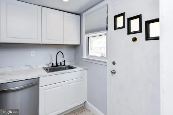 a kitchen with stainless steel appliances granite countertop white cabinets and sink