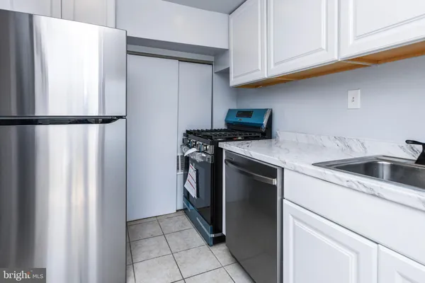 a kitchen with a refrigerator sink and cabinets