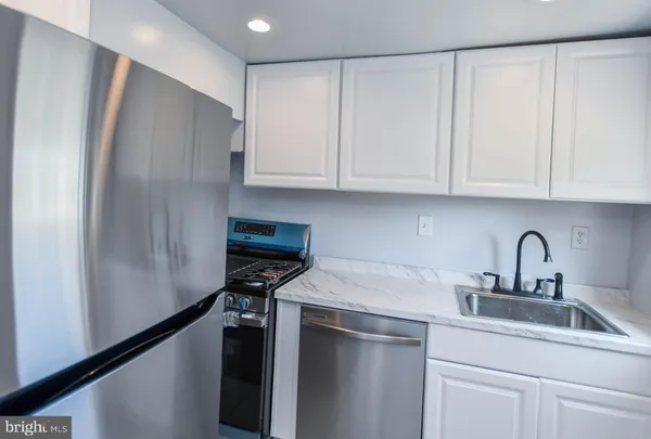 a kitchen with stainless steel appliances a refrigerator sink and cabinets